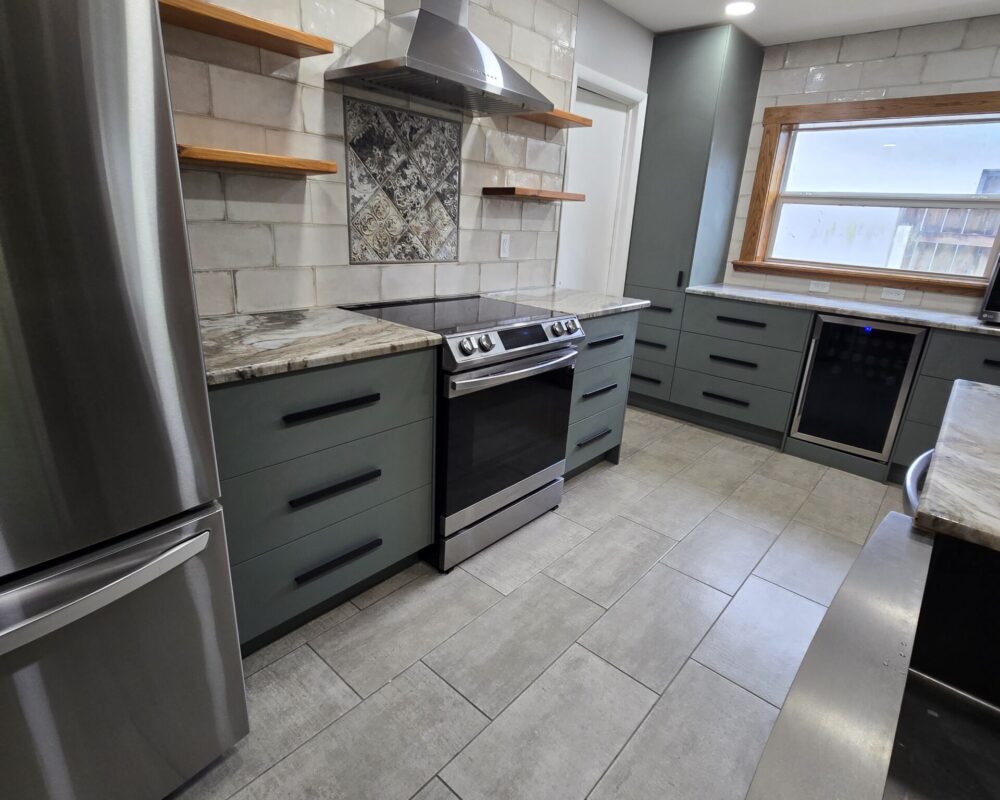 Modern kitchen remodel featuring sleek gray cabinetry, stainless steel appliances, and a stylish backsplash, showcasing TurnKey Builds' craftsmanship in South Florida home renovations.