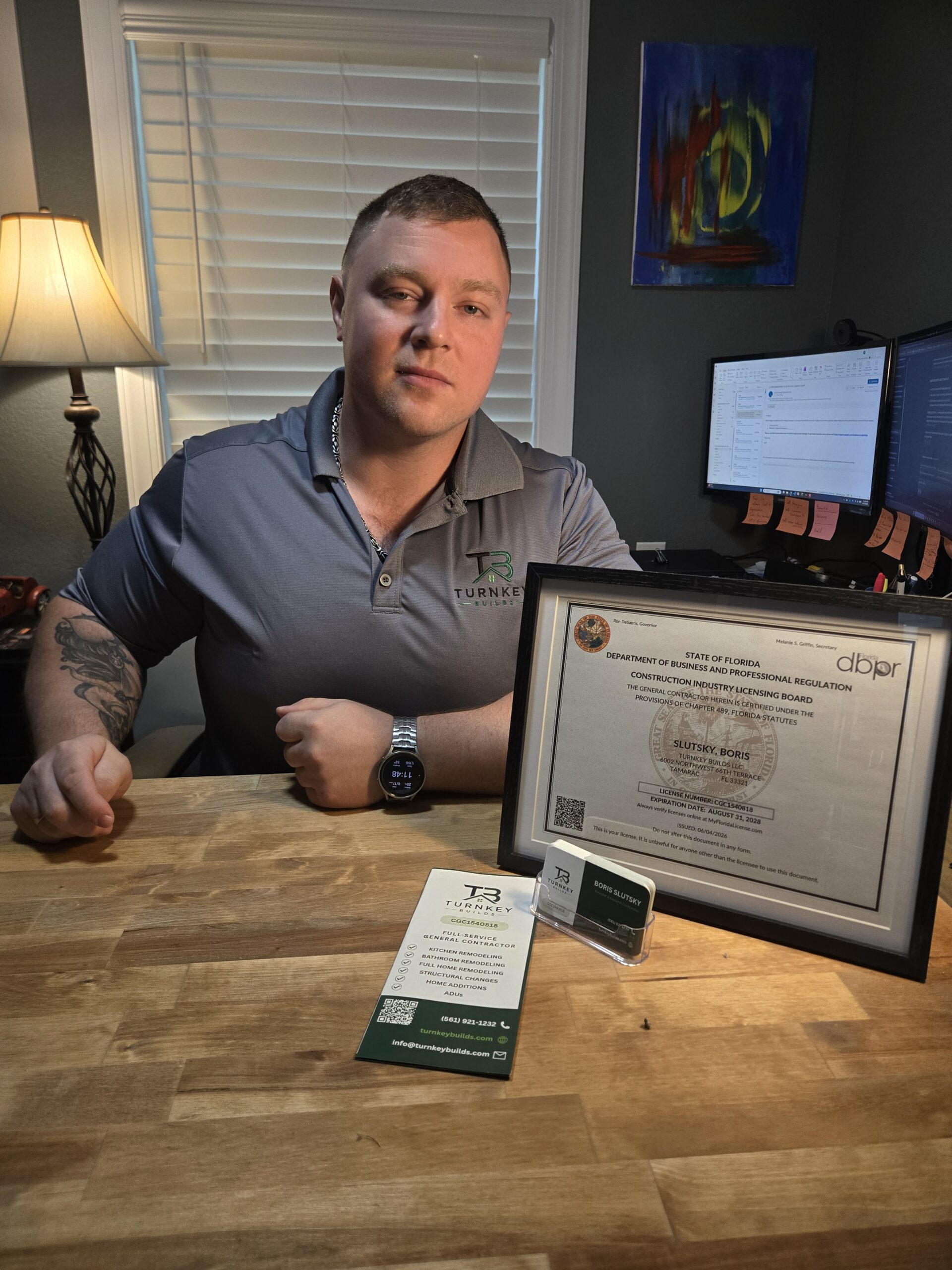 Bathroom contractor displaying Florida license and Turnkey Builds business card.