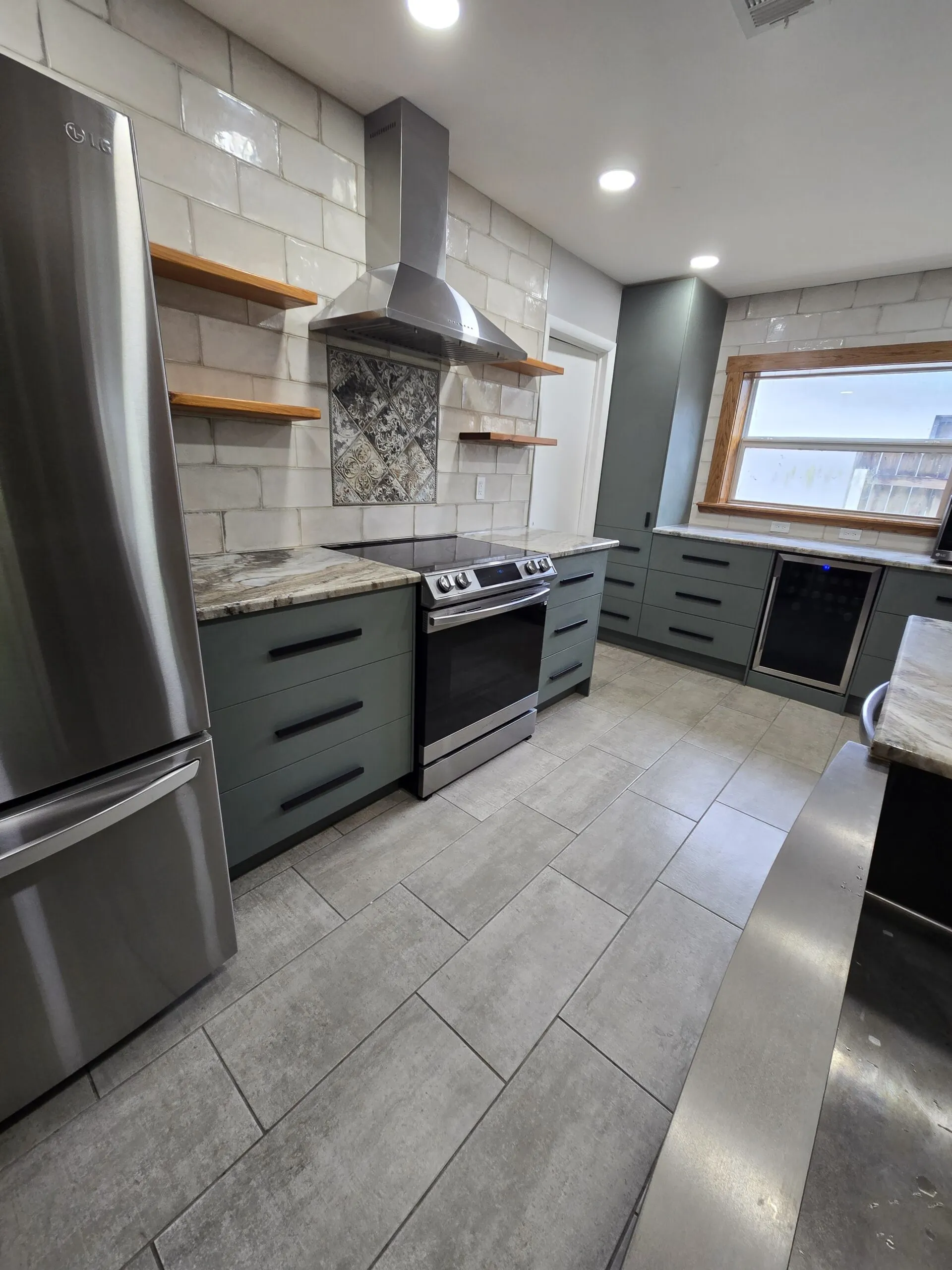Modern South Florida kitchen with gray cabinetry, quartz countertops, and stainless steel range hood and appliances.